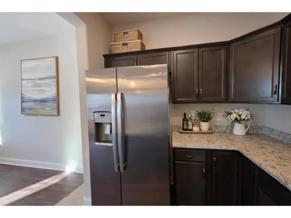 a kitchen with granite countertop stainless steel appliances a refrigerator and cabinets