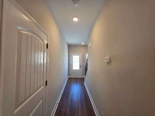 a view of a hallway with wooden floor