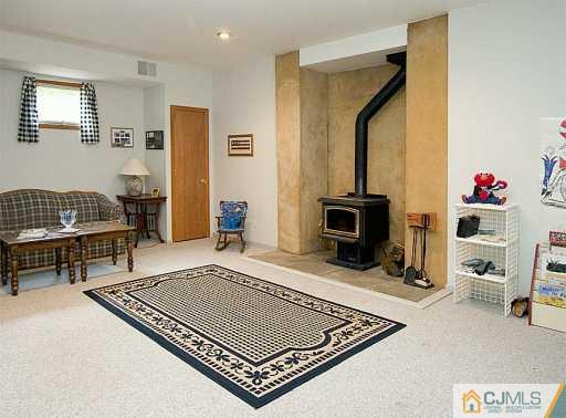 115 Hollow Road Skillman, NJ 08558 - Photo 6 of 8 a living room with furniture a rug and a fireplace