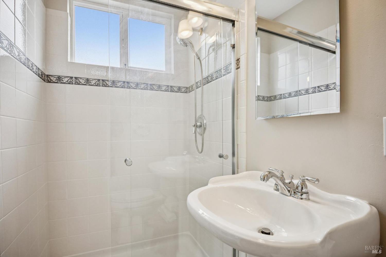 35 San Pablo Avenue San Rafael, CA 94903 - Photo 28 of 43 a bathroom with a sink a mirror and shower