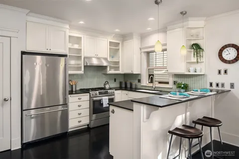 a kitchen with stainless steel appliances a refrigerator a stove a sink and a refrigerator