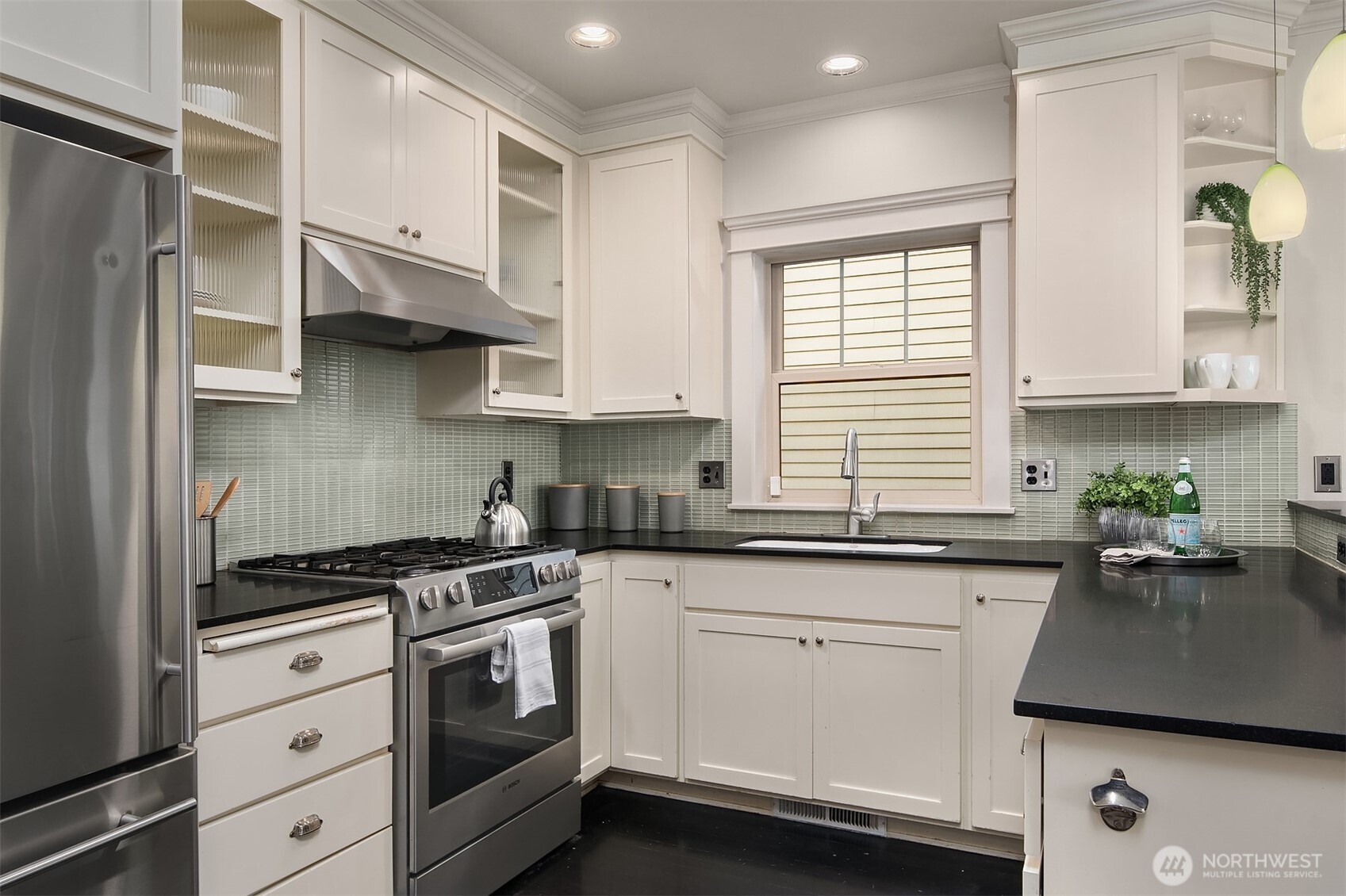 527 11th Avenue East, Unit A Seattle, WA 98102 - Photo 12 of 37 a kitchen with stainless steel appliances white cabinets and a stove top oven