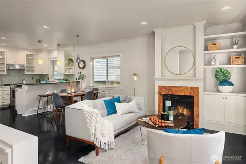 a living room with furniture a fireplace and a large window