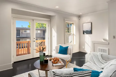 a living room with furniture a wooden floor and a large window