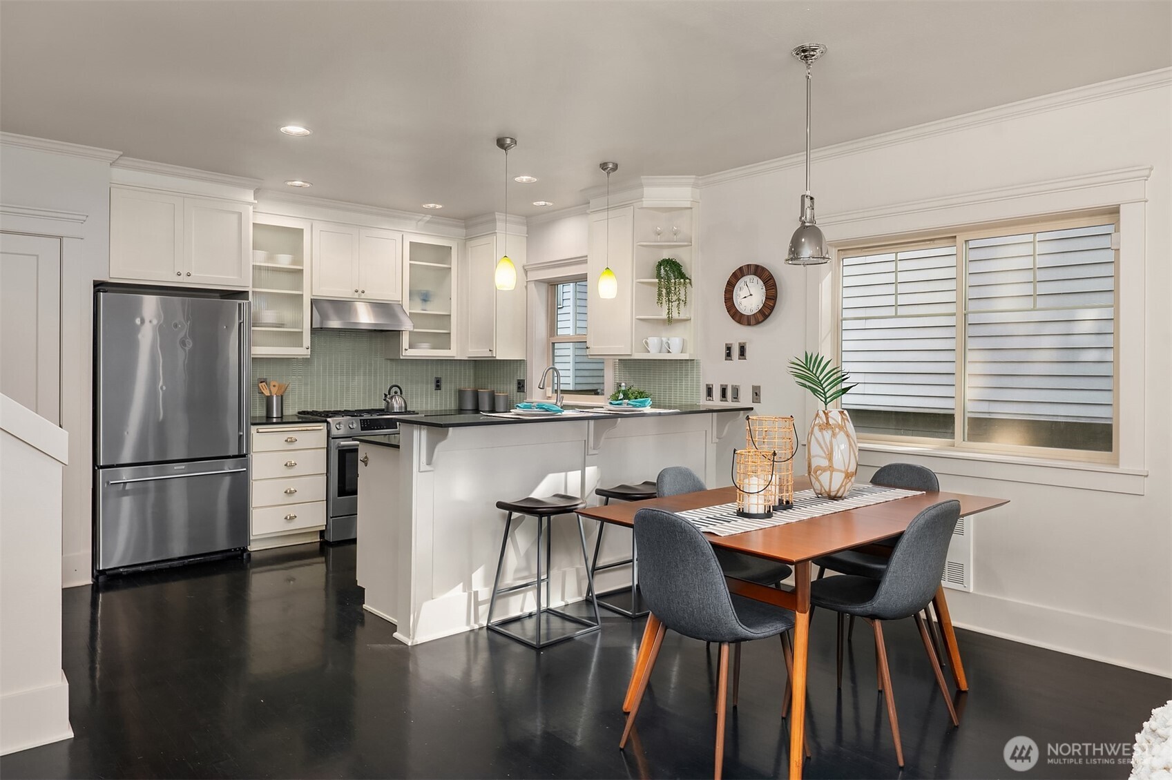 527 11th Avenue East, Unit A Seattle, WA 98102 - Photo 10 of 37 a kitchen with stainless steel appliances granite countertop a dining table chairs a sink a stove and a refrigerator