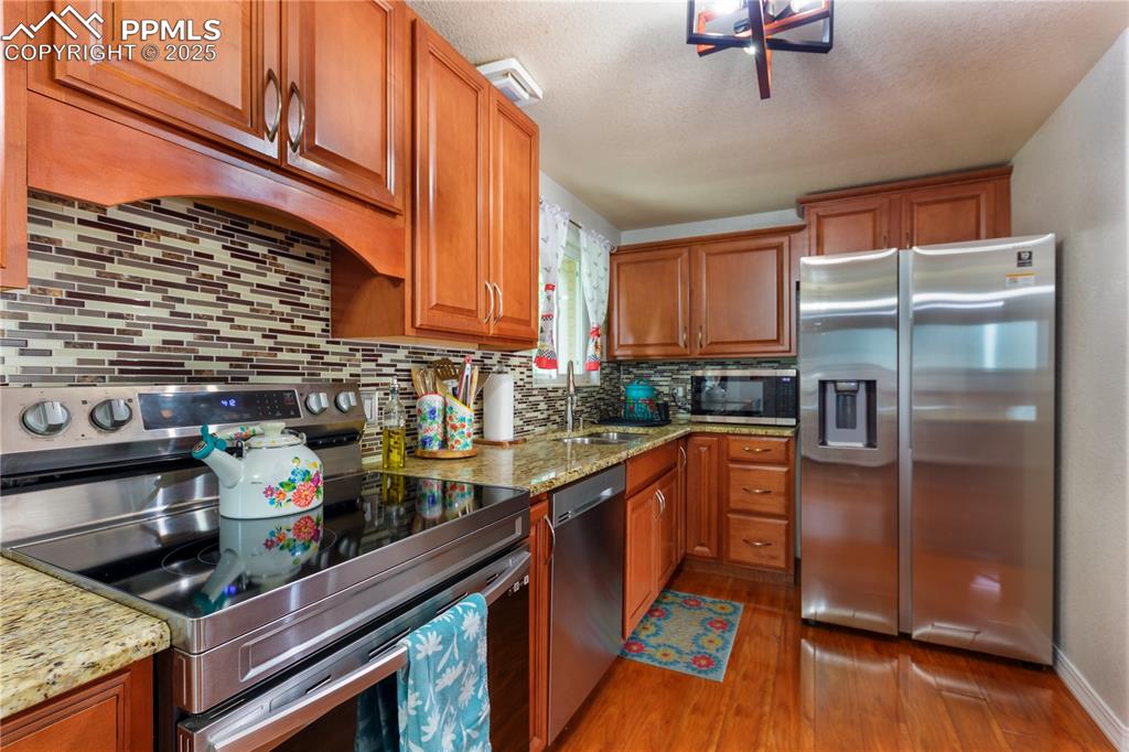 2205 Airport Road Colorado Springs, CO 80910 - Photo 12 of 40 a kitchen with stainless steel appliances granite countertop a refrigerator and a stove