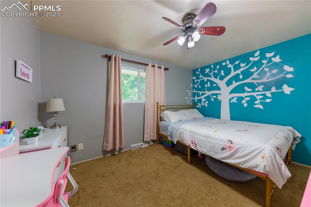 2205 Airport Road Colorado Springs, CO 80910 - Photo 22 of 40 a bedroom with a bed and a chandelier