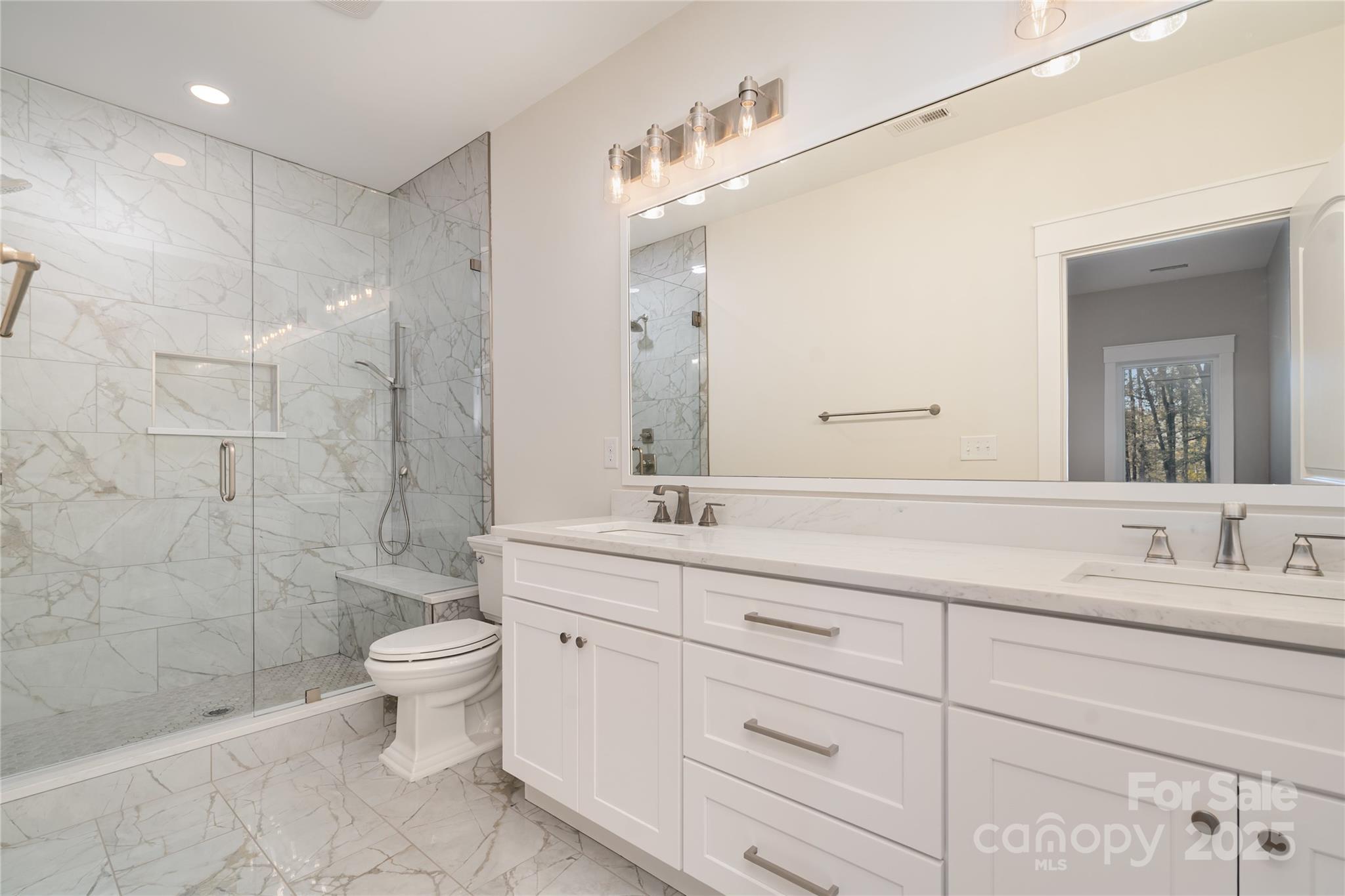 6632 Silver Fox Road Charlotte, NC 28270 - Photo 32 of 42 a bathroom with a double vanity sink a toilet and a shower