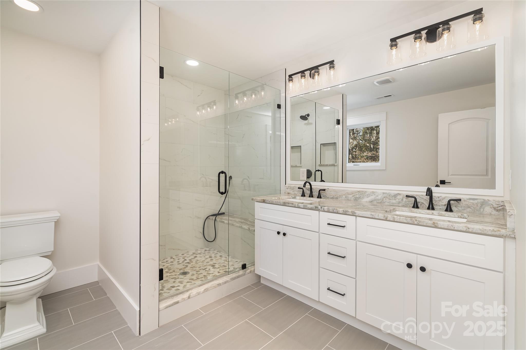 6632 Silver Fox Road Charlotte, NC 28270 - Photo 35 of 42 a en suite bathroom with a granite countertop sink a toilet and shower