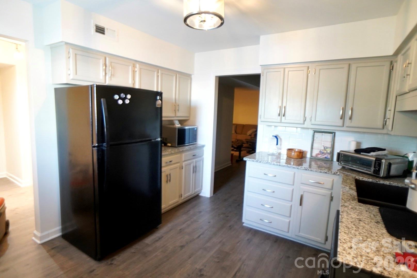 2705 North Center Street, Unit 36 Hickory, NC 28601 - Photo 4 of 21 a kitchen with stainless steel appliances granite countertop a refrigerator a stove a sink and white cabinets with wooden floor