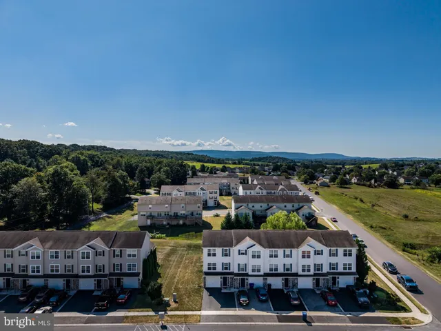 a kitchen with stainless steel appliances granite countertop a sink a stove a refrigerator cabinets a dining table and chairs