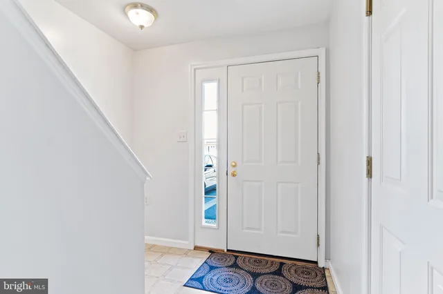 a living room with furniture and a dining table with kitchen appliances