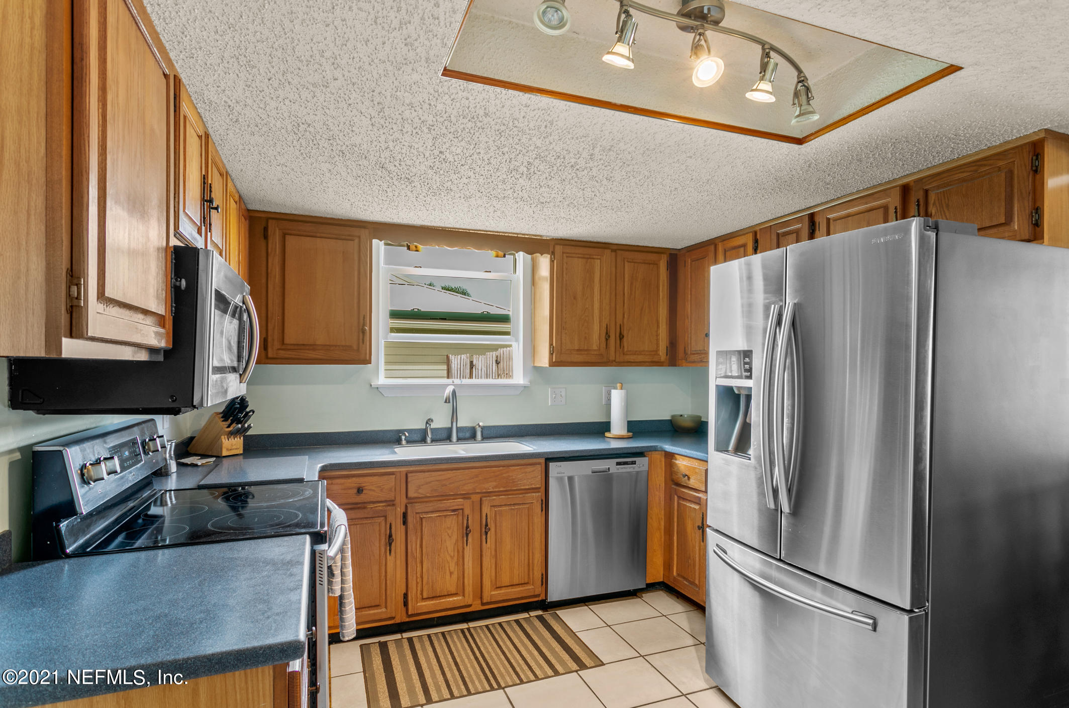 10841 Reading Road Jacksonville, FL 32257 - Photo 4 of 25 a kitchen with stainless steel appliances granite countertop a refrigerator a sink dishwasher a stove and white countertops with wooden floor