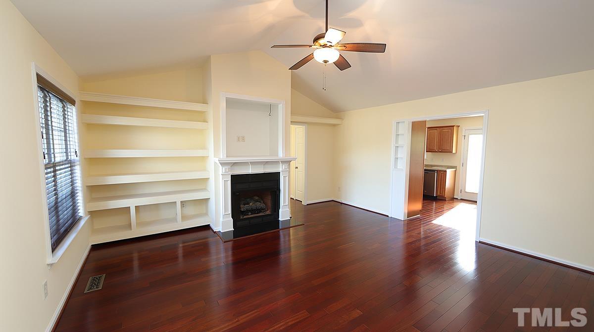 435 Ridge Road Angier, NC 27501 - Photo 16 of 29 View from front door to living area with hardwood floors, cathedral ceiling, fireplace and built-in bookshelves.