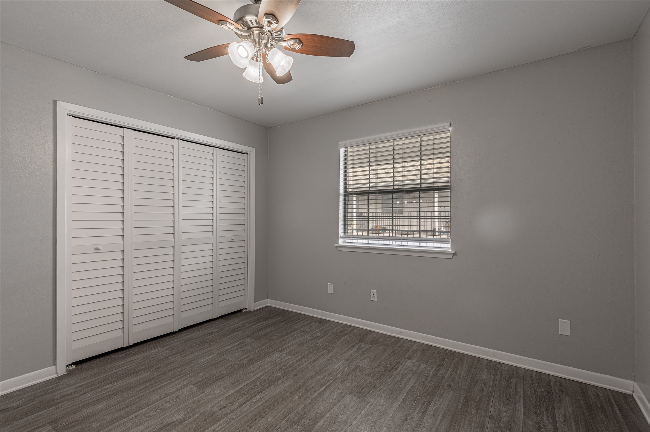 600 Palm Street, Unit 16 Huntsville, TX 77340 - Photo 16 of 21 an empty room with wooden floor chandelier fan and windows