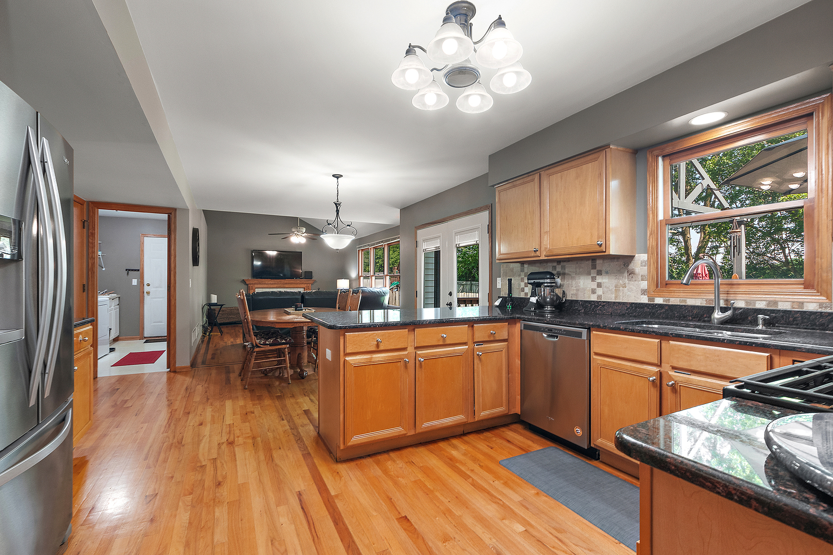 24929 Vermette Road Plainfield, IL 60585 - Photo 6 of 31 a kitchen with stainless steel appliances granite countertop a stove top oven a dining table and chairs with wooden floor