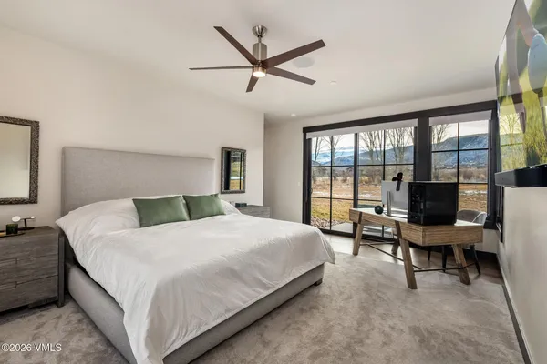 a bedroom with a bed and a large window