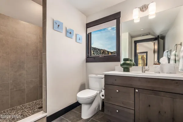 a bathroom with a toilet a sink and mirror