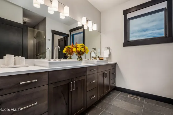 a bathroom with a double vanity sink and a mirror