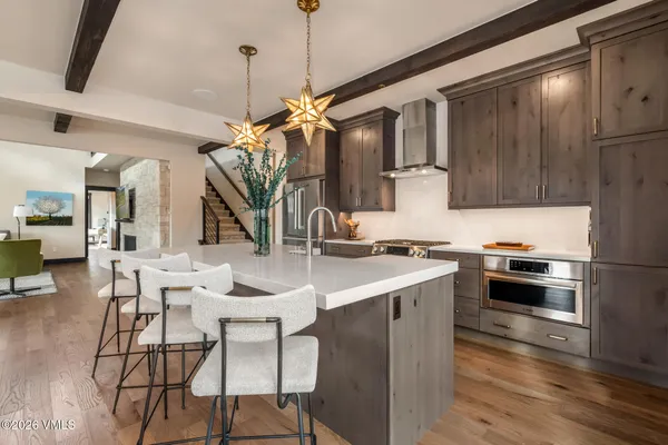 a kitchen with stainless steel appliances kitchen island a table and chairs in it
