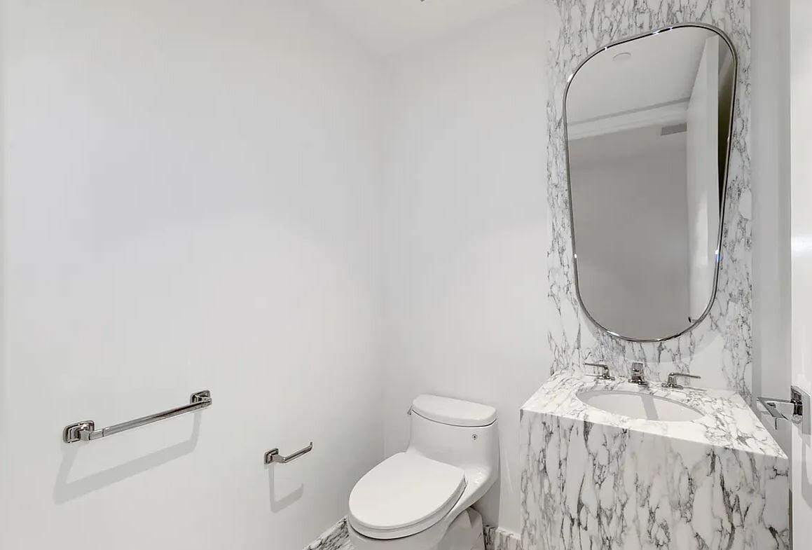 50 West 66th Street, Unit 9G Manhattan, NY 10023 - Photo 5 of 13 a bathroom with a granite countertop sink mirror vanity and toilet