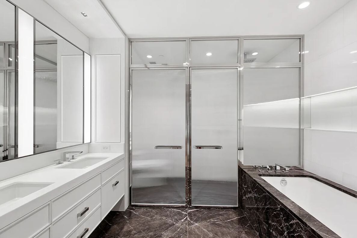 50 West 66th Street, Unit 9G Manhattan, NY 10023 - Photo 9 of 13 a bathroom with a double vanity sink mirror and shower