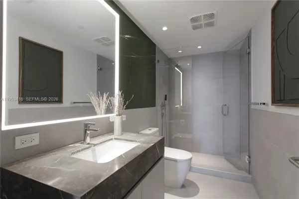 a bathroom with a granite countertop sink toilet and shower