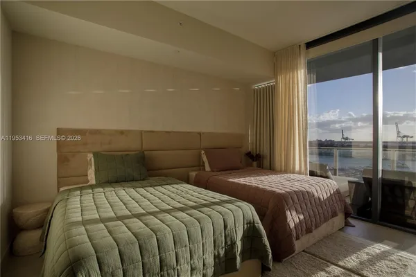 a bedroom with a large bed and a large window