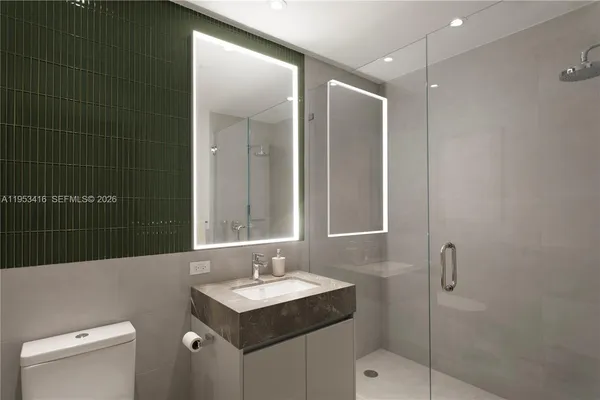 a bathroom with a sink toilet vanity and shower