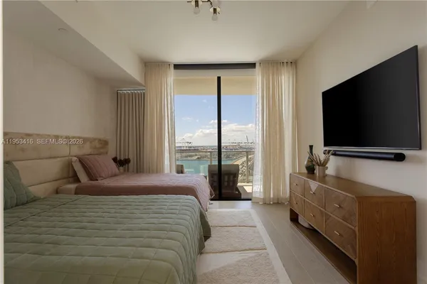 a bedroom with a bed and a flat screen tv