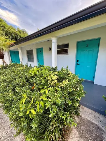 a view of a house with a yard and potted plants