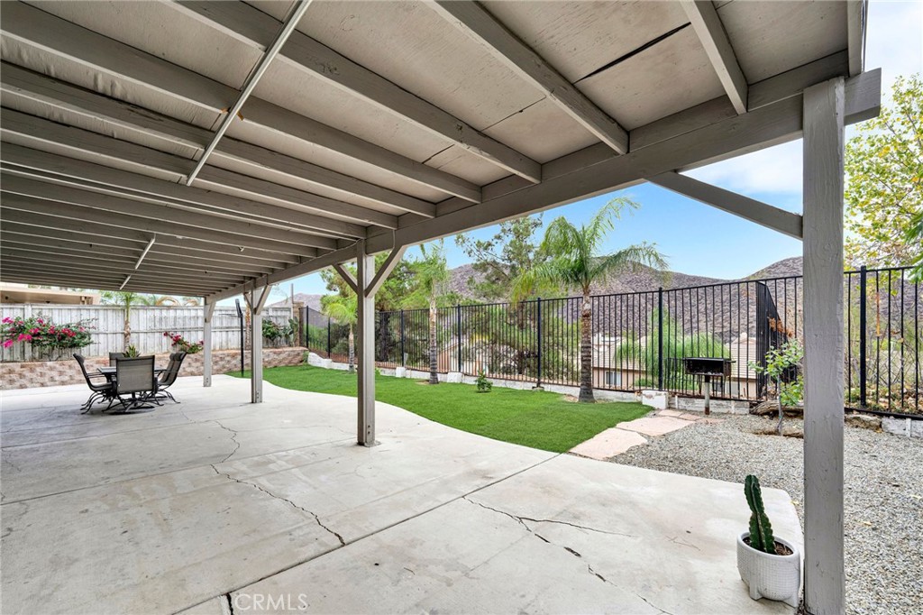 31755 Ridgeview Drive Lake Elsinore, CA 92532 - Photo 7 of 36 a view of a patio with a table and chairs under an umbrella with a roof