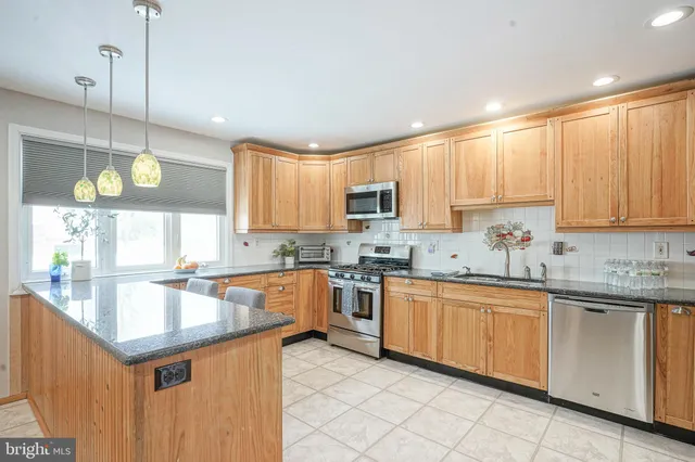 a kitchen with a sink counter top space cabinets and stainless steel appliances