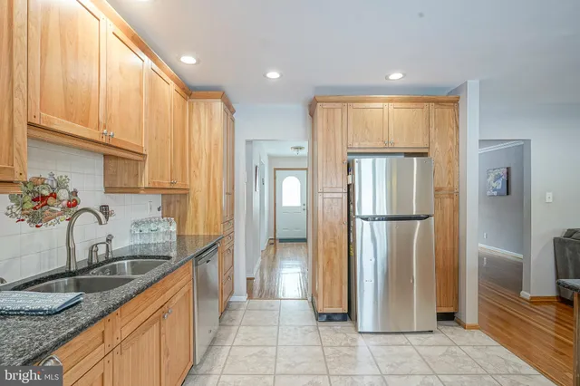 a kitchen with stainless steel appliances granite countertop a refrigerator and a sink