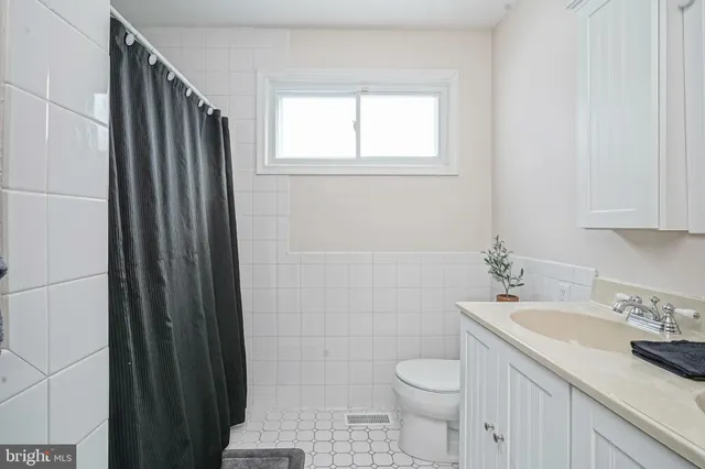 a bathroom with a granite countertop sink toilet and a mirror