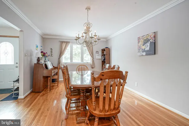 a dining room with furniture a chandelier and wooden floor