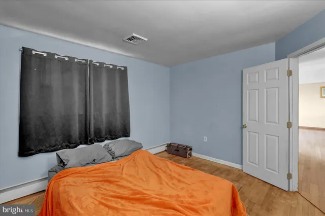 a bed sitting in a bedroom next to a window