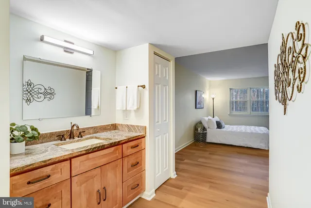 a en suite bathroom with a granite countertop sink and a mirror