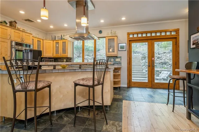 a kitchen with stainless steel appliances granite countertop table chairs and wooden floor