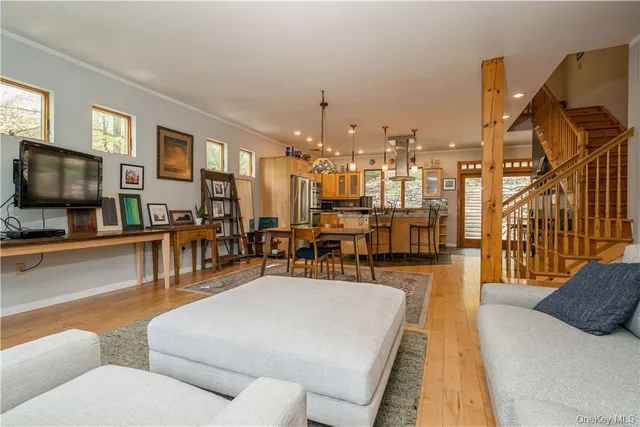 a living room with furniture a flat screen tv and kitchen view