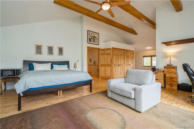 a spacious bedroom with a bed a couch and dresser