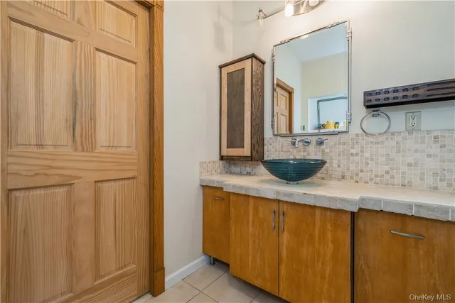a bathroom with a granite countertop sink and a mirror