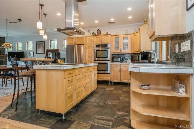 a kitchen with stainless steel appliances granite countertop a stove top oven a sink dishwasher a dining table and chairs