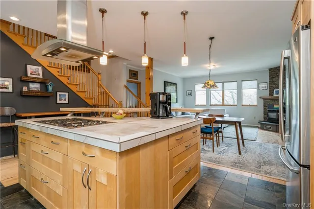 a kitchen with a stove a refrigerator a sink and chairs