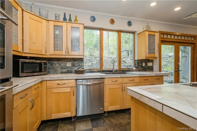 a kitchen with stainless steel appliances granite countertop a stove a sink and a microwave