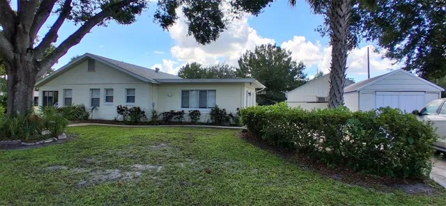 a front view of a house with a yard and trees