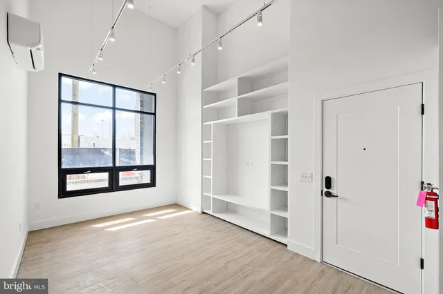 an empty room with windows and closet
