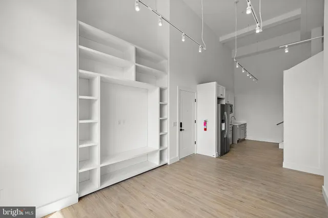 a view of empty room with wooden floor and window