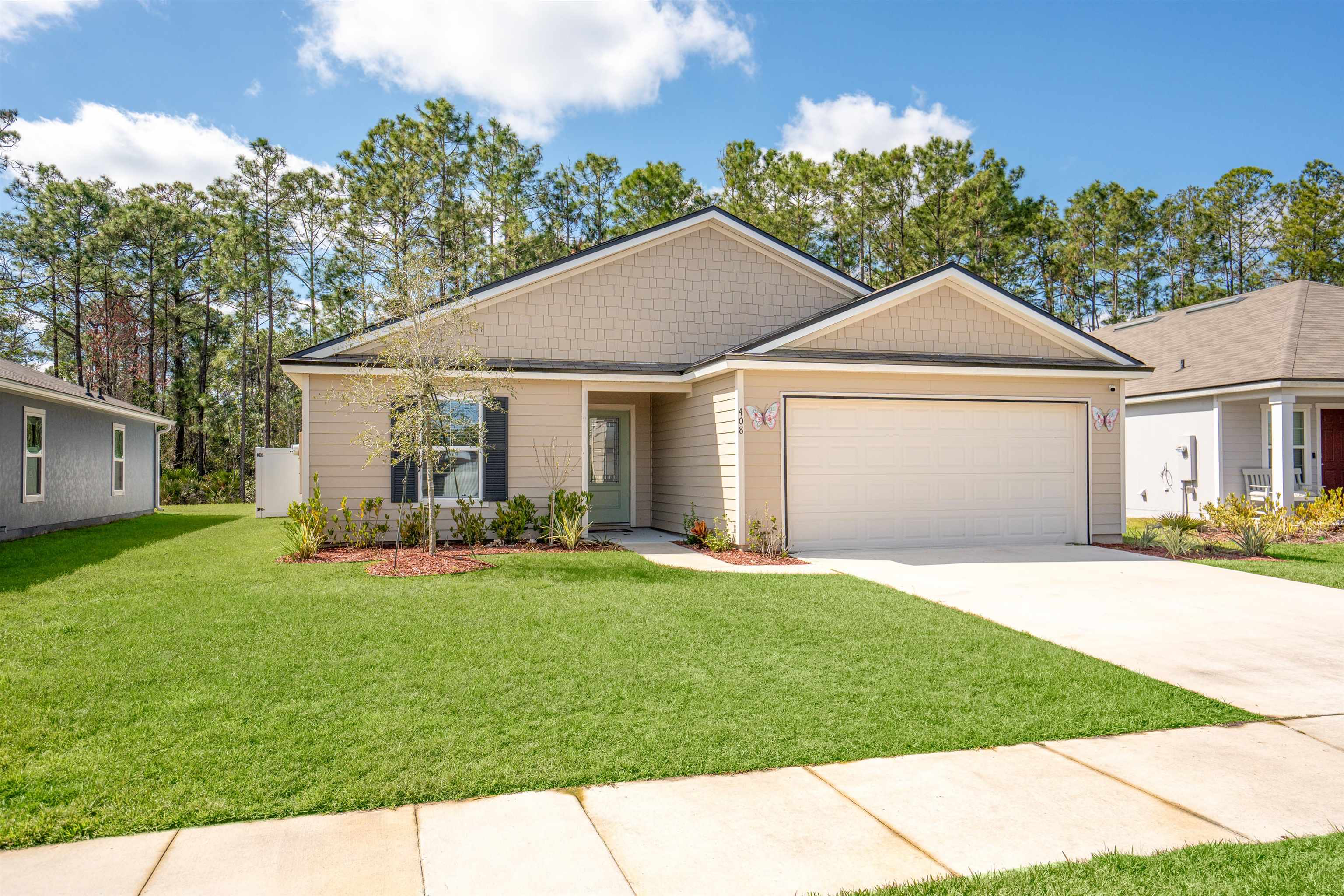408 Falcon Ridge Road St. Augustine, FL 32084 - Photo 1 of 26 a front view of a house with a yard and garage