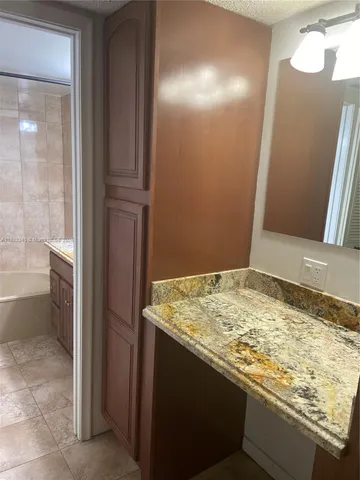 a bathroom with a granite countertop sink and a toilet